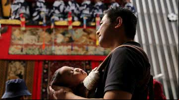 Homem japonês segura seu bebê dormindo - Getty Images
